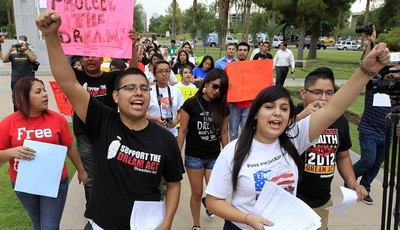 
              FILE - In this Aug. 16, 2012 file photo, Joshua Montano, left, and Deborah Robles protest in front of the Capitol the day after Arizona Gov. Jan Brewer, in an executive order reaffirmin